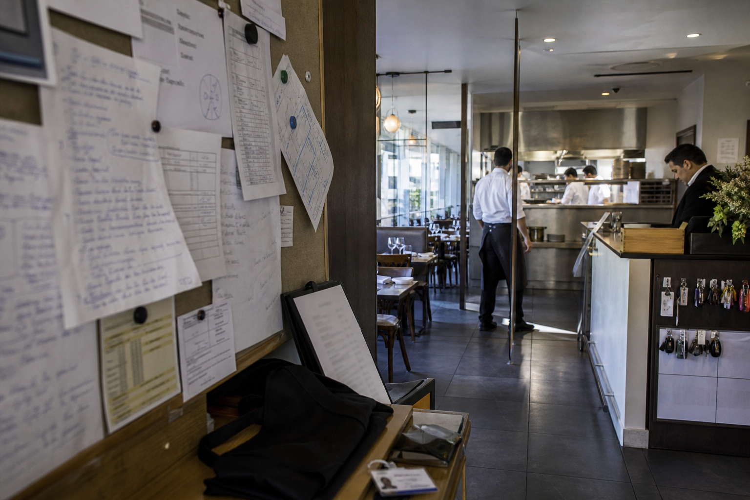 Notice de prévention dans un espace RH de restaurant, avec vue sur la salle et la cuisine en arrière-plan